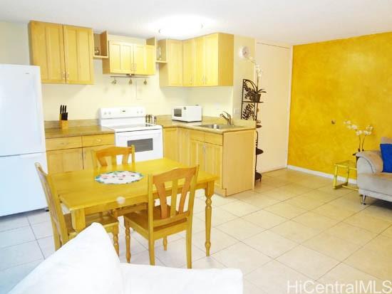 2572 Lemon Road, Unit 306 Honolulu, HI 96815 - Photo 9 of 13 a kitchen with stainless steel appliances a stove a refrigerator a sink and white cabinets with wooden floor