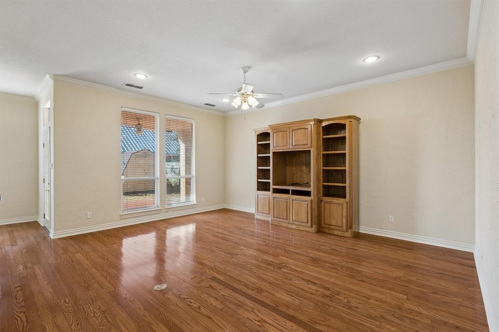 1727 Ridgecrest Drive Cleburne, TX 76033 - Photo 10 of 32 Wood-finish flooring, entertainment center with shelving, recessed lighting, ceiling fan, and multiple windows