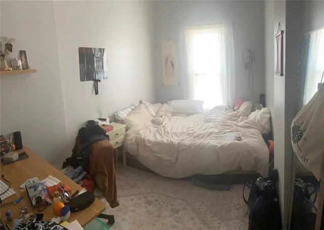 a bedroom with a bed and a window