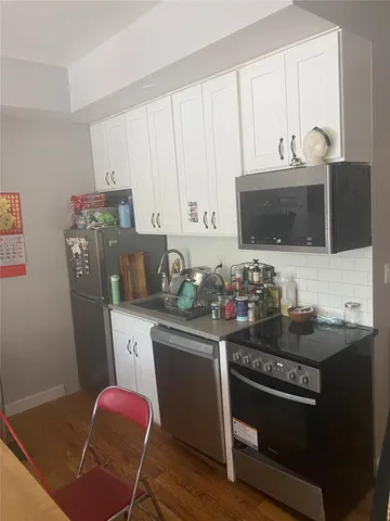 a kitchen with granite countertop a sink stove and cabinets