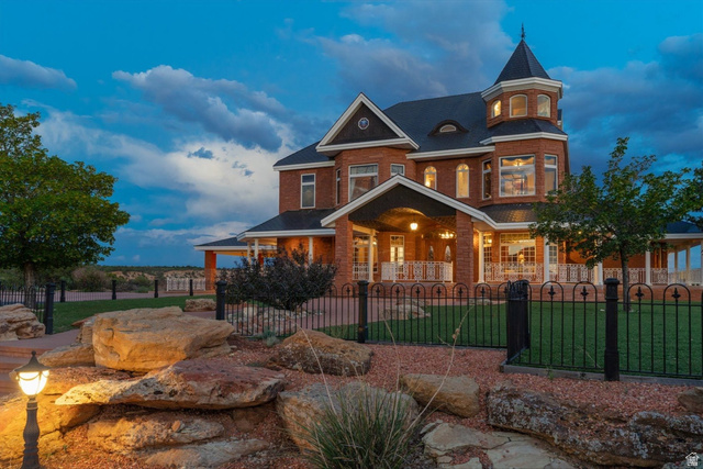 5615 East Eight Mile Gap Road Kanab, UT 84741 - Photo 69 of 81 View of front of house with a porch, a fenced front yard, brick siding, and a gate