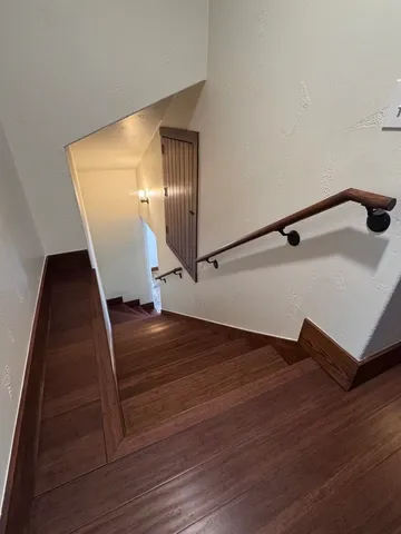a view of an empty room with wooden floor