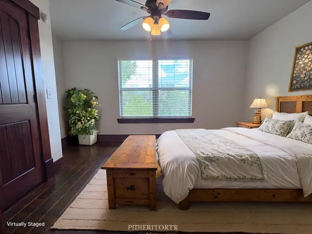 a bedroom with a bed table and a window