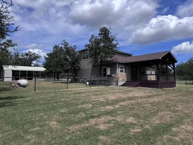 a view of a house with backyard and porch
