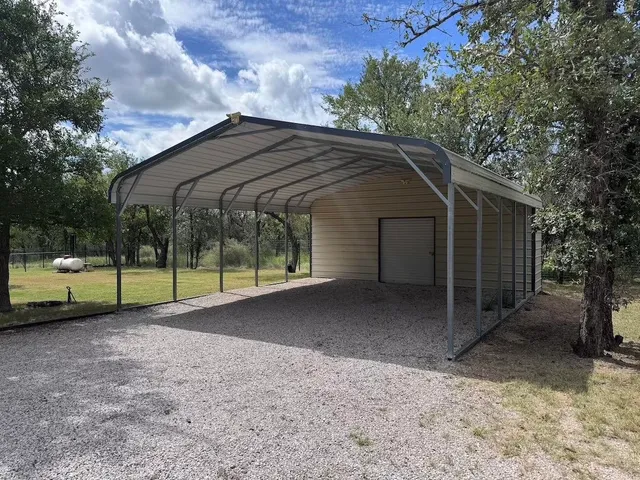 a view of a house with a backyard and a large tree
