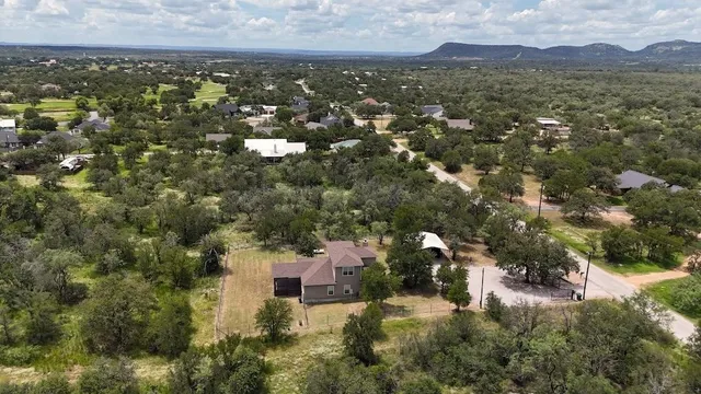 an aerial view of residential houses with outdoor space and trees
