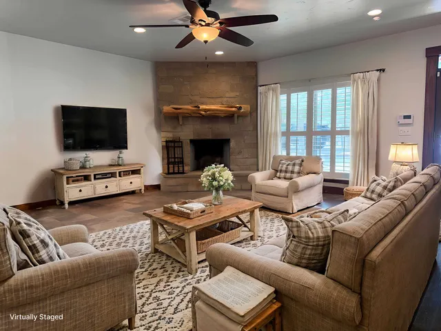 a living room with furniture a flat screen tv and a fireplace
