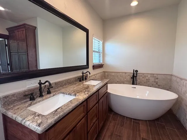 a bathroom with a granite countertop sink and a large mirror