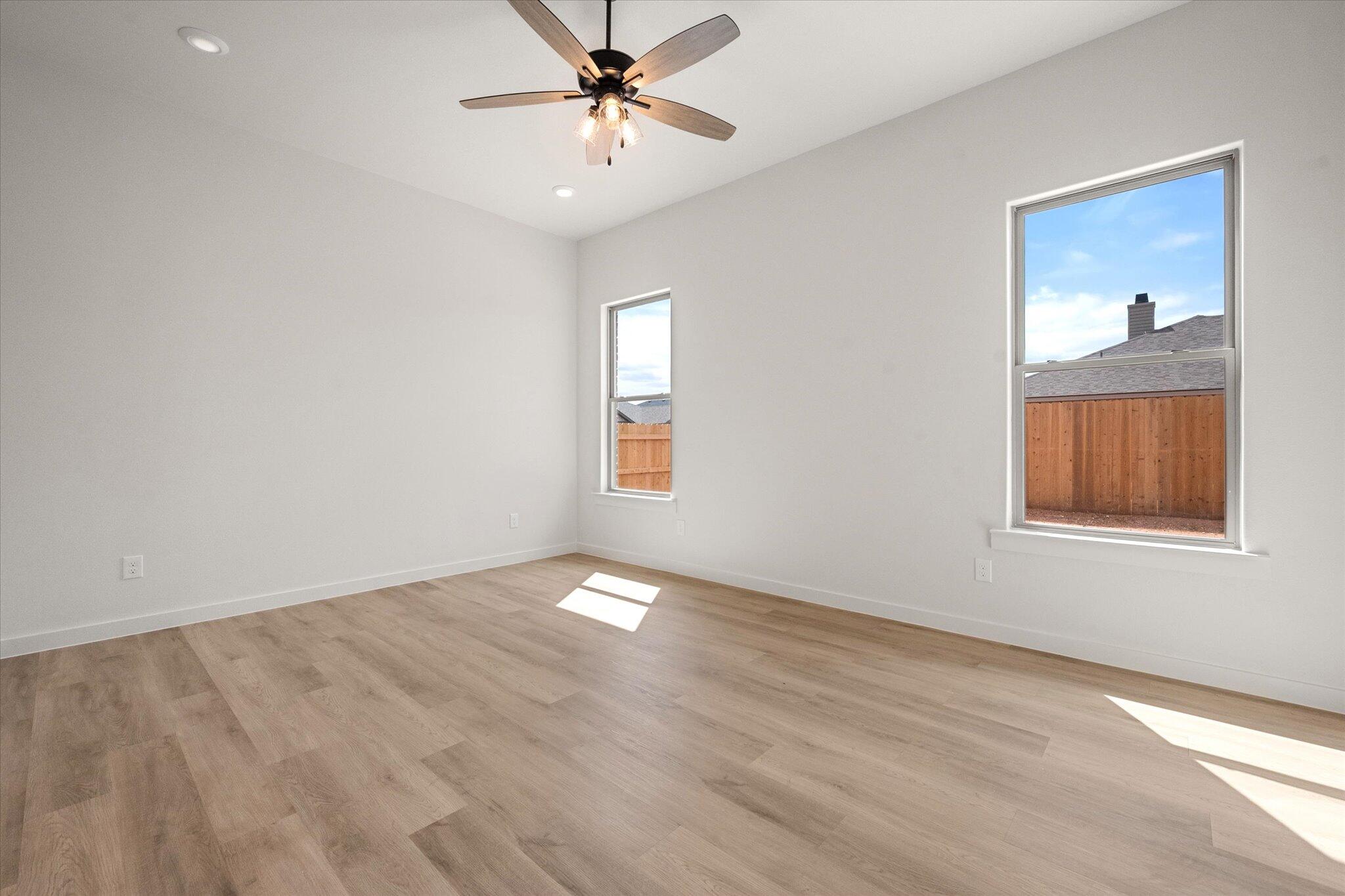313 East 23rd Street Wolfforth, TX 79382 - Photo 12 of 22 wooden floor in an empty room with a window