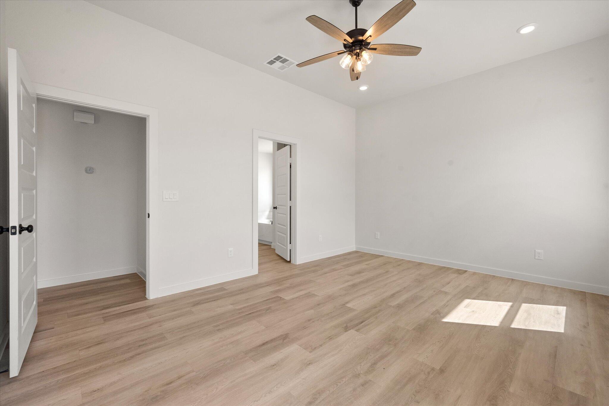 313 East 23rd Street Wolfforth, TX 79382 - Photo 13 of 22 an empty room with wooden floor fan and windows