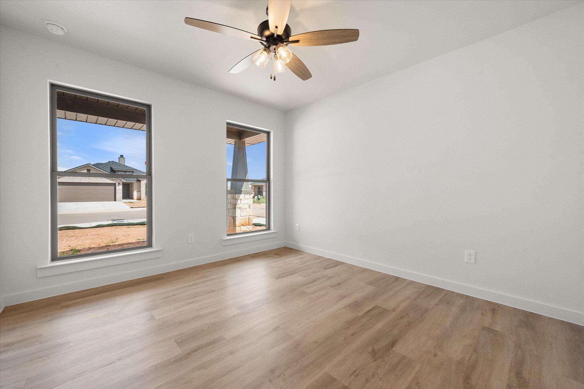 313 East 23rd Street Wolfforth, TX 79382 - Photo 18 of 22 an empty room with windows and fan