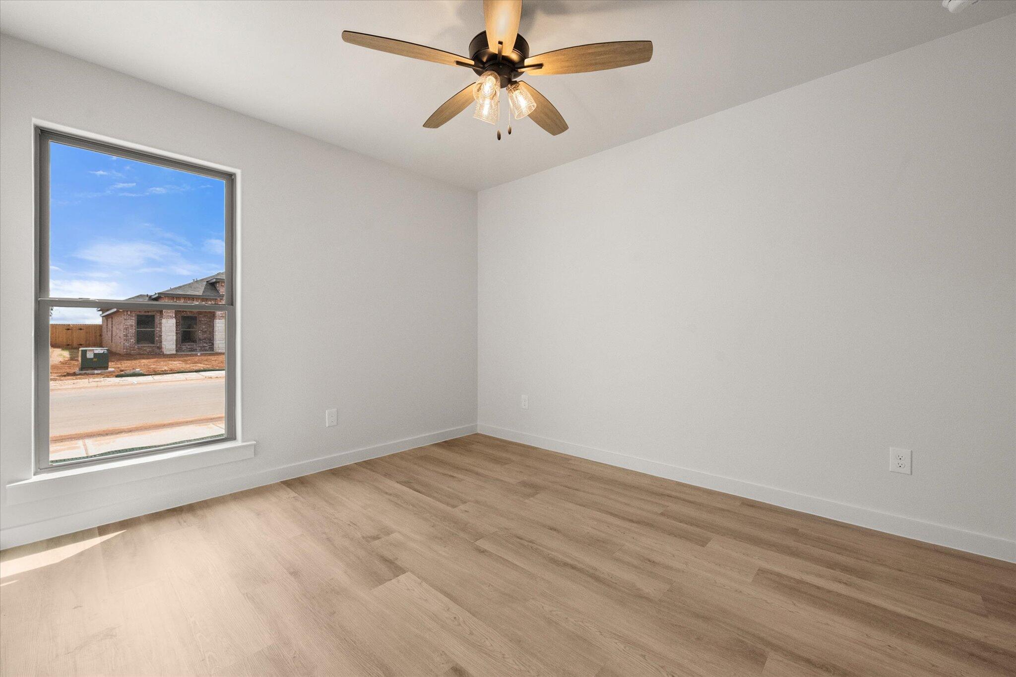 313 East 23rd Street Wolfforth, TX 79382 - Photo 19 of 22 wooden floor in an empty room with a window