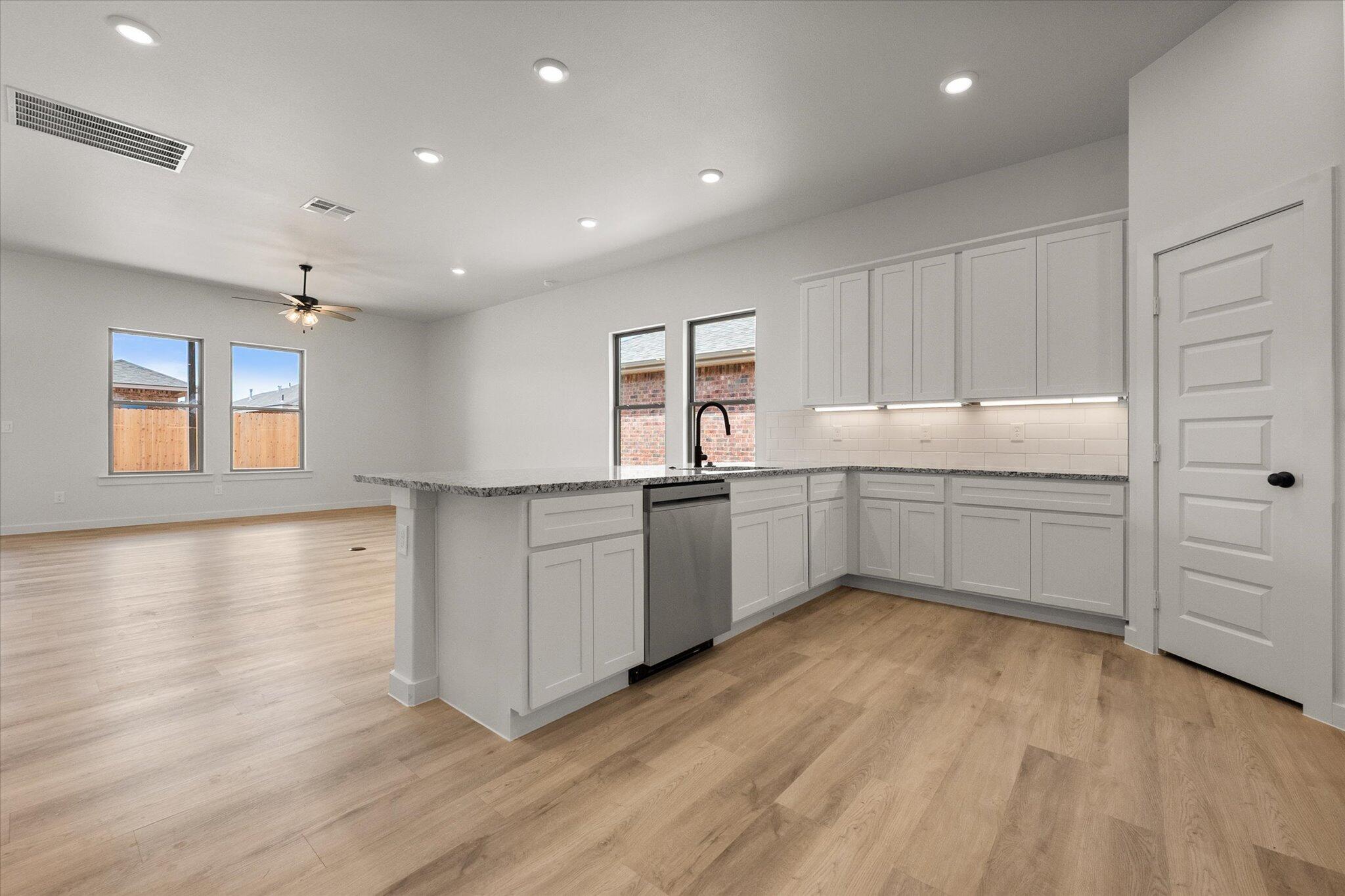 313 East 23rd Street Wolfforth, TX 79382 - Photo 3 of 22 a kitchen with a white wooden cabinets and white appliances