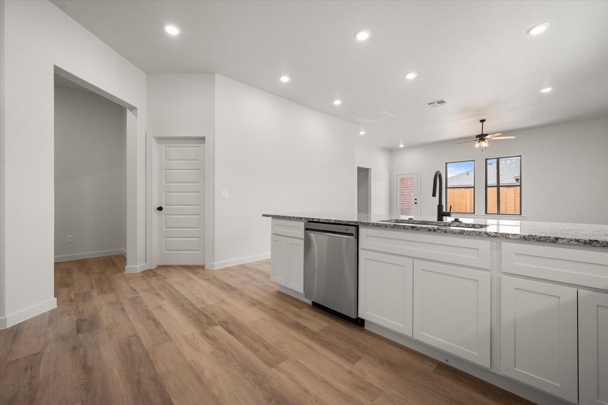 313 East 23rd Street Wolfforth, TX 79382 - Photo 7 of 22 a large kitchen with granite countertop a sink and a stove top oven
