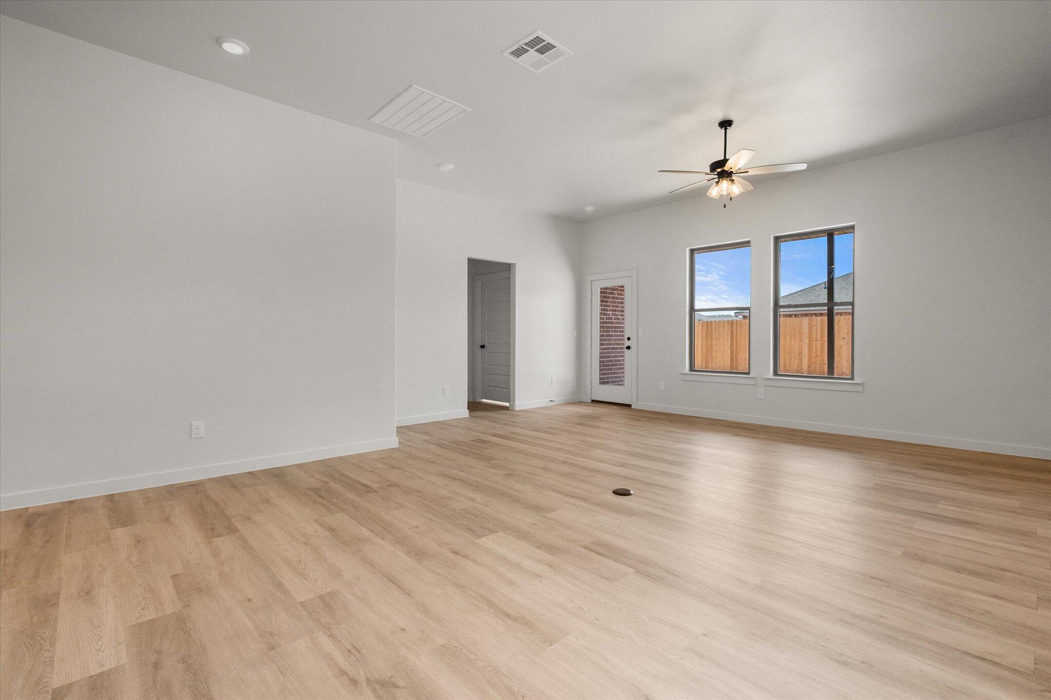 313 East 23rd Street Wolfforth, TX 79382 - Photo 9 of 22 a view of empty room with wooden floor and fan