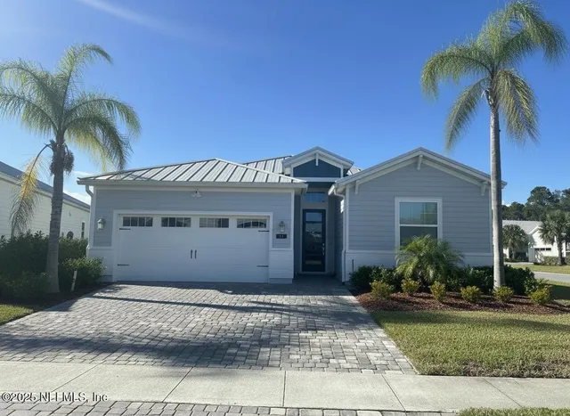 a view of a house with a yard and palm trees