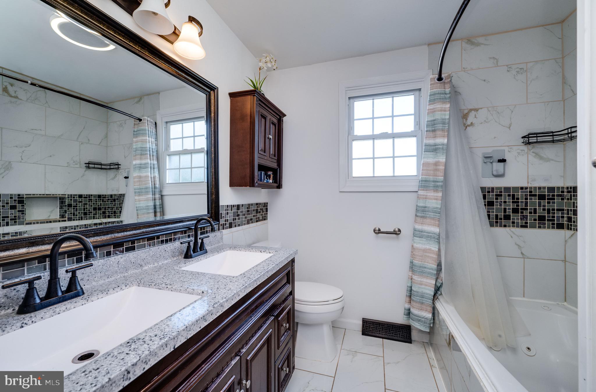 1005 Landover Drive Reading, PA 19605 - Photo 10 of 46 a bathroom with a granite countertop sink a toilet a mirror and shower