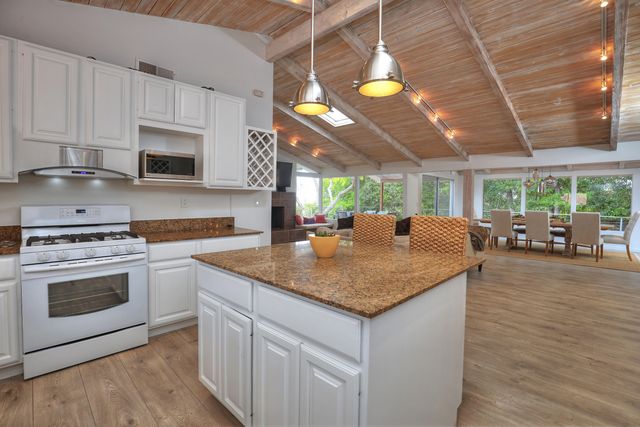 a kitchen with stainless steel appliances granite countertop a stove a sink and a microwave