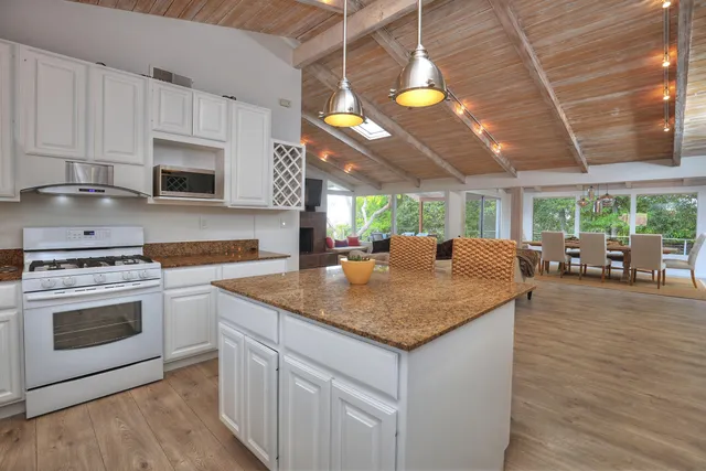 a kitchen with stainless steel appliances granite countertop a stove a sink and a microwave