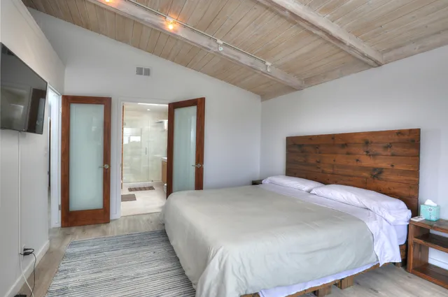 a bedroom with a bed and glass door