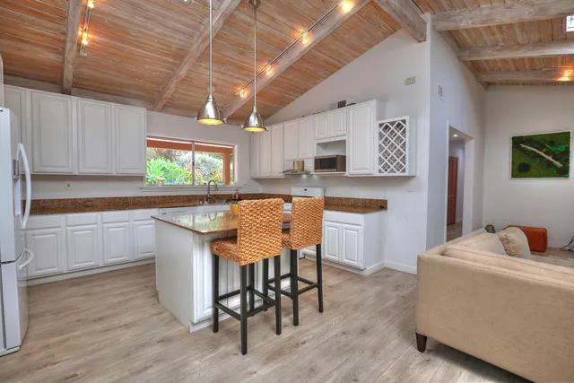 a kitchen with stainless steel appliances granite countertop a table chairs sink and cabinets