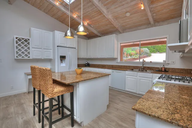 a kitchen with stainless steel appliances granite countertop a sink counter space and a window