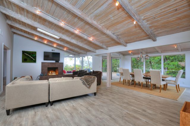 a living room with furniture large windows and a fireplace