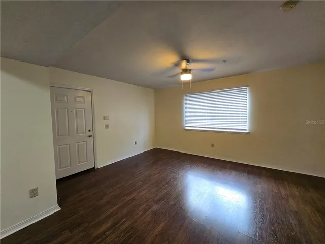 a view of empty room with wooden floor