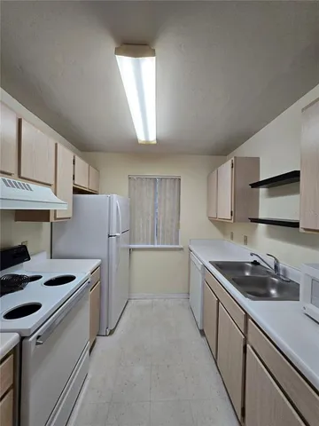 a kitchen with a sink and refrigerator