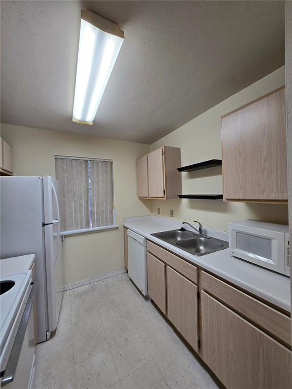 2360 Southwest Archer Road, Unit 604 Gainesville, FL 32608 - Photo 9 of 16 a kitchen with a sink and refrigerator