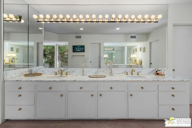 a bathroom with double vanity sinks and a mirror