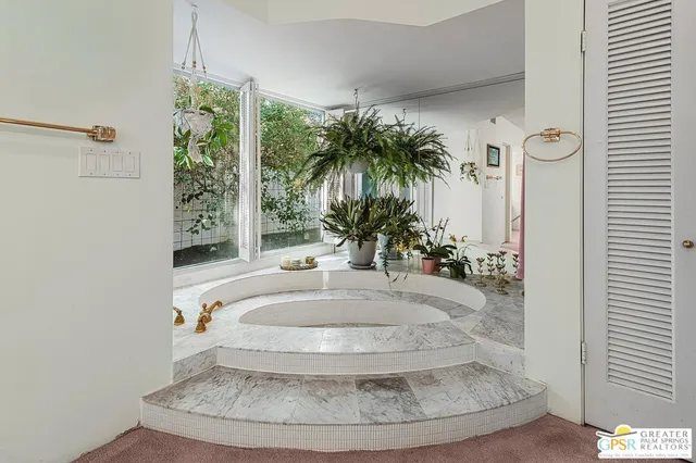 a bedroom with a bed and large windows