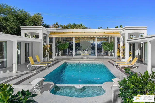 a view of swimming pool with outdoor seating and plants