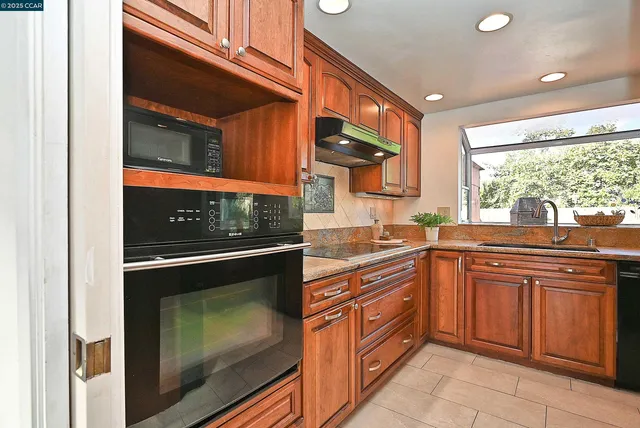 a kitchen with stainless steel appliances granite countertop a stove and a microwave