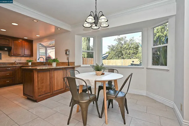 a dining room filled chandelier and wooden floor