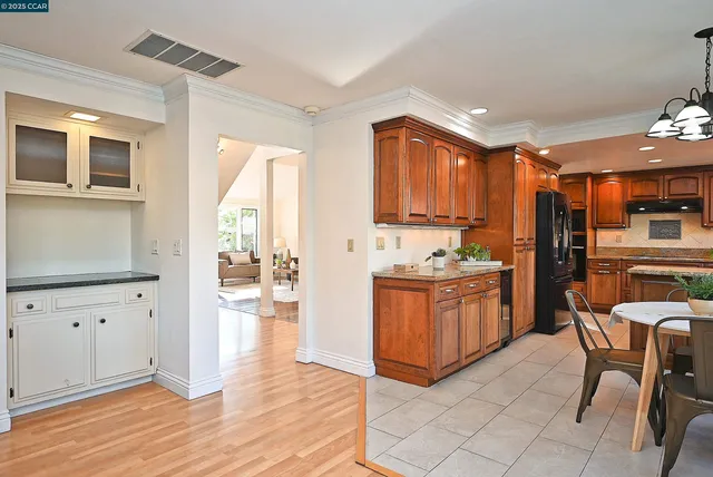 a kitchen with granite countertop a stove a sink and a refrigerator