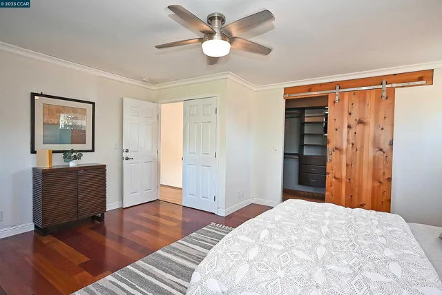 a bedroom with furniture closet and wooden floor
