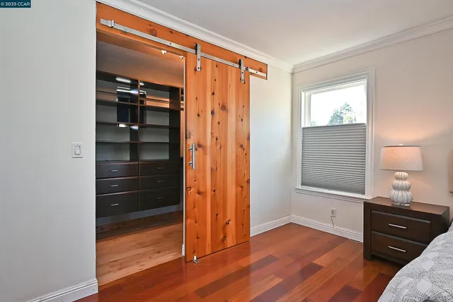 a view of a room with wooden floor closet and windows