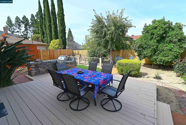 a view of deck with seating space and trees in the background