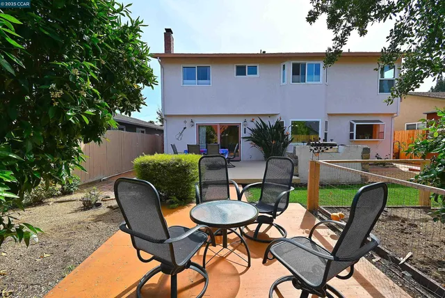 a view of a patio with table and chairs potted plants and a palm tree