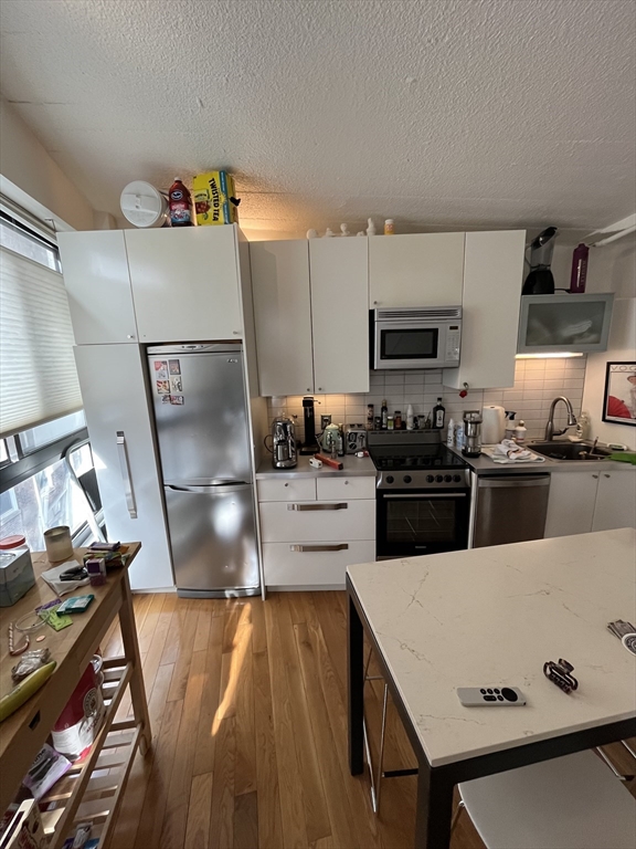 12 Stoneholm Street, Unit 322 Boston, MA 02115 - Photo 6 of 33 a kitchen with stainless steel appliances refrigerator stove microwave and sink