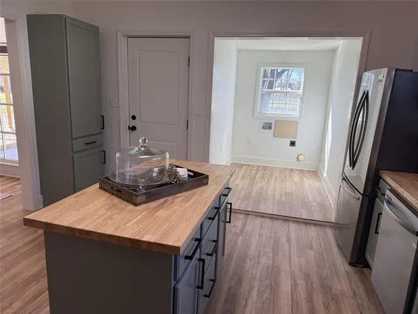 a living room with hard wood floors and a refrigerator