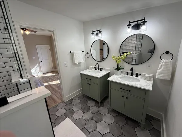 a bathroom with a double vanity sink and a mirror