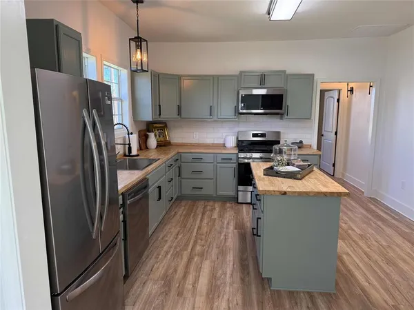 a kitchen with stainless steel appliances a refrigerator a stove a sink and a refrigerator