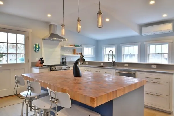 a kitchen with stainless steel appliances granite countertop a kitchen island a stove a table and chairs