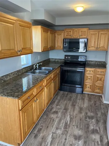 a kitchen with stainless steel appliances granite countertop a stove microwave and sink