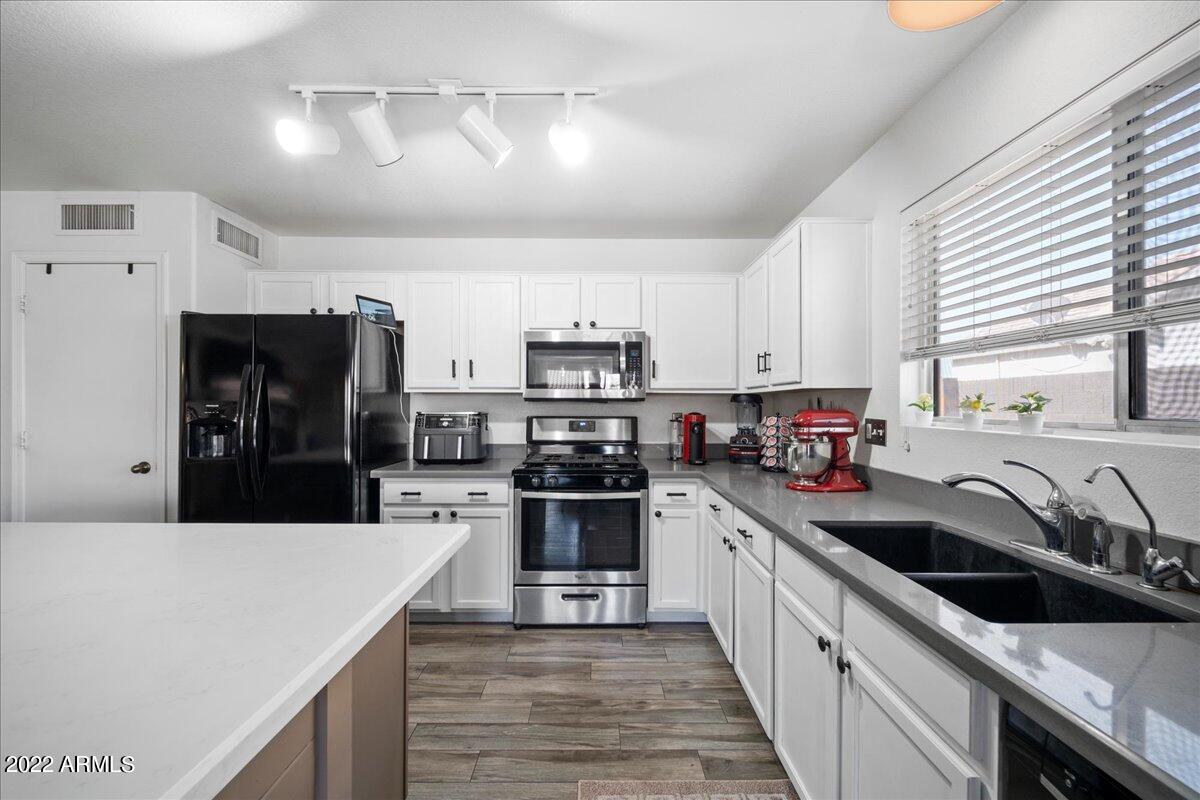 1836 East Darrel Road Phoenix, AZ 85042 - Photo 12 of 28 a kitchen with stainless steel appliances a sink dishwasher a stove top oven a refrigerator and cabinets