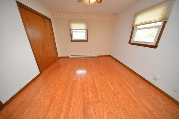 a view of a room with wooden floor and a window