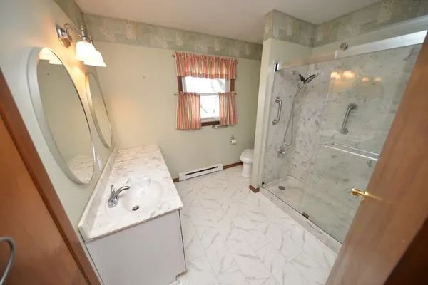 a bathroom with a tub sink and mirror