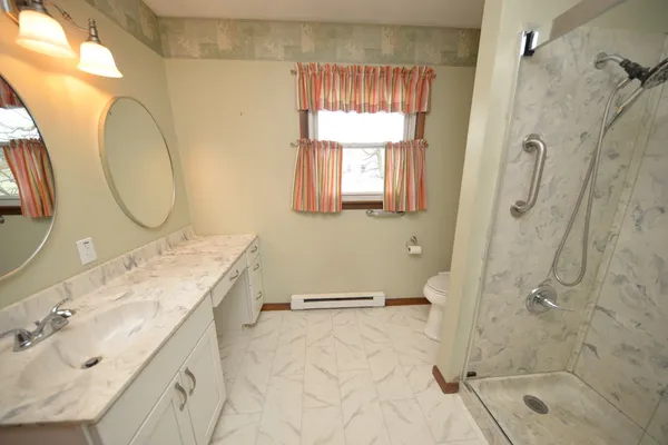a bathroom with a granite countertop sink toilet and shower